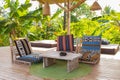 Lounge chairs with pillows and wooden table on the terrace. Cozy patio in hotel resort. Empty tourist villa. Royalty Free Stock Photo