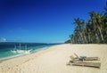 Lounge chairs and traditional boat on puka beach in boracay phil Royalty Free Stock Photo