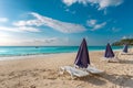 Lounge chairs with umbrellas on a beach in Antigua with clear blue water Royalty Free Stock Photo