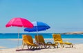 Lounger chairs and parasol umbrellas on sandy beach in Cape Town