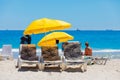 Lounger chairs and parasol umbrellas on sandy beach in Cape Town