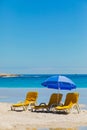 Lounger chairs and parasol umbrellas on sandy beach in Cape Town