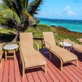 Loungers on the deck by the seafront Tobago Caribbean square compositon. Royalty Free Stock Photo