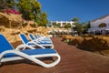 Loungers near the pool, luxury buildings and palm trees behind Royalty Free Stock Photo