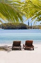 Loungers under a palm tree on a tropical beach Royalty Free Stock Photo