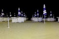 Lounges and closed umbrellas on night beach Royalty Free Stock Photo