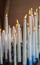 Big burning candles from prayers for hope. Saint Bernadette grotto with many white candles with flame. Sanctuary in Lourdes.