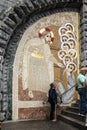 Lourdes, France, 24 June 2019: Mosaic of the studio of Marko Rupnik on the wall in front of the entrance to the Rosary Basilica in