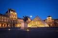 Louvre museum and the pyramid illuminated at night in Paris, France Royalty Free Stock Photo