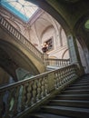 Louvre Palace architectural details of a hall with stone staircase, ornate railings and glowing vintage lamps, Paris, France