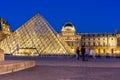 Louvre palace and pyramid at night in Paris, France Royalty Free Stock Photo