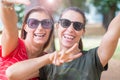 Smiling caucasian girls expressing positive emotions to camera making victory sign with his hands