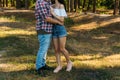 embrace.Love and affection between a young couple at the park. a guy in a plaid plane and jeans, a girl in shorts and a white jack Royalty Free Stock Photo