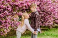 Love is in the air. Couple adorable lovely kids walk sakura garden. Tender love feelings. Little girl and boy. Romantic