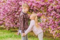 Love is in the air. Couple adorable lovely kids walk sakura garden. Tender love feelings. Little girl and boy. Romantic