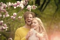 Love is in the air. girl and guy, couple in love in spring magnolia flowers Royalty Free Stock Photo