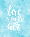 Love is in the air Hand drawn creative calligraphy and brush pen lettering on blue watercolour background.