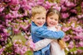 Love is in the air. Kids in love pink cherry blossom. Romantic babies. Couple kids walk sakura tree garden. Tender love