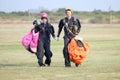 Love is in the air! Man and woman skydivers walking hand in hand