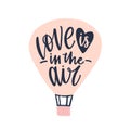 Love Is In The Air phrase handwritten with elegant cursive calligraphic font on air balloon. Modern romantic lettering