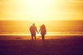 Love is in the air. Rearview shot of an affectionate mature couple walking hand in hand on the beach. Royalty Free Stock Photo