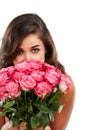 Love is in the air and it smells like roses. Studio portrait of a young woman holding a bouquet of flowers against a Royalty Free Stock Photo