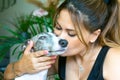 Love for animals. Portrait of a young Caucasian woman kissing her greyhound dog