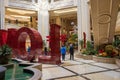 The Love Art Sculpture in the waterfall atrium at The Venetian Resort and Hotel with lush green trees and plants, colorful flowers Royalty Free Stock Photo