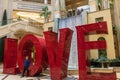 The Love Art Sculpture in the waterfall atrium at The Venetian Resort and Hotel with lush green trees and plants, colorful flowers Royalty Free Stock Photo