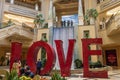 The Love Art Sculpture in the waterfall atrium at The Venetian Resort and Hotel with lush green trees and plants, colorful flowers Royalty Free Stock Photo