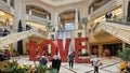 The Love Art Sculpture in the waterfall atrium at The Venetian Resort and Hotel with lush green trees and plants, colorful flowers Royalty Free Stock Photo