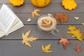 Love autumn, coffee and books. cup of cappuccino stands on the table among a collection of colorful bright fallen leave Royalty Free Stock Photo