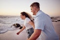 Love, beach and couple holding hands running to the water on a romantic sunset evening together outdoors in nature Royalty Free Stock Photo