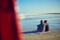 Love is a beautiful thing. Rearview shot of a young couple sitting on the beach. Royalty Free Stock Photo