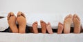 Love, bed and closeup of family feet relaxing, laying and bonding in the bedroom with a blanket. Zoom of a mother Royalty Free Stock Photo