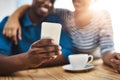 Love is the best thing worth sharing. a young man and woman using a mobile phone together on a date at a coffee shop. Royalty Free Stock Photo