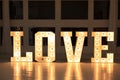 Love big white letters with led retro bulbs glowing. Word LOVE with a big letters. Inscription is love. Glowing large letters.