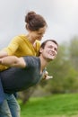Love brings out their lighter side. a happy man giving his wife a piggyback ride outside.