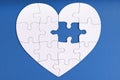 Love, charity, donation, helping concept. Missing piece of jigsaw puzzle in heart shape on blue. Looking for love partner.