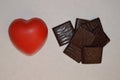 Love chocolate. Red heart shape ball next to lots of chocolate