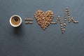 Love coffee concept. Heart from roasted coffee beans and cup of coffee on black background Royalty Free Stock Photo