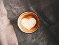 Love of coffee. Top view of a black coffee mug filled with hot coffee with cinnamon, with a white heart painted on top