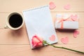 Love composition - coffee cup, gift box and rose on pink background, top view.