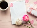 Love composition - coffee cup, gift box and roses on pink background, top view.