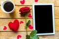 Love composition - flat lay photo with coffee cup, red rose and black mockup tablet.