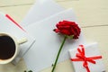 red rose, coffee cup and gift box on wooden table