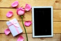 Love composition - rose, gift box and mockup black tablet on wooden background.