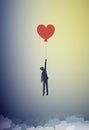 In love concept, boy silhouette holds the red heart shaped balloon and flying up to the sky, dreamer concept, shadow