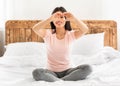 Cheerful Asian Girl Gesturing Heart Shape Sitting On Bed Indoors Royalty Free Stock Photo