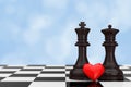 Love Concept. Chess King and Queen Figures with Red Heart over C